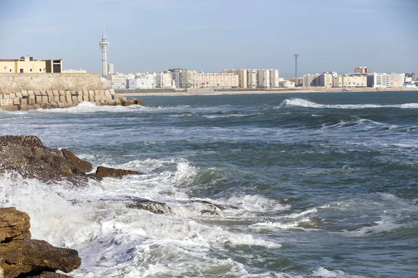 Vågorna slog stenar på strandpromenaden i La Caleta stranden i Cadiz, Spanien — Stockfoto