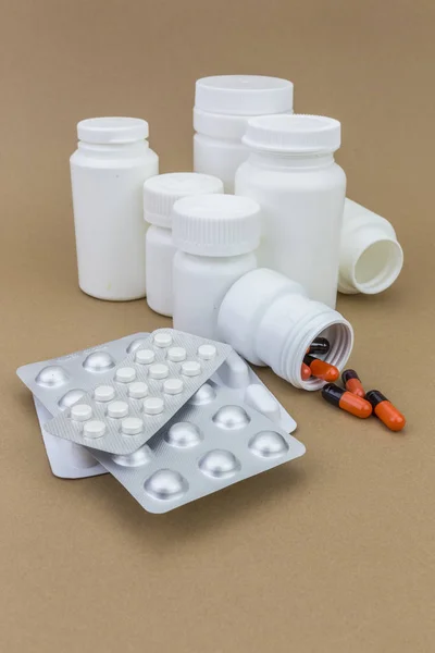 Orange och brunt piller, set vit behållare plast — Stockfoto