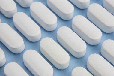 Üzerinde mavi arka plan izole flecla şeklinde bazı haplar hizalı