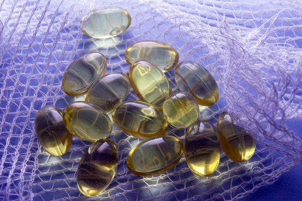 Alcune pillole bianche avvolte in una garza su uno sfondo blu — Foto Stock