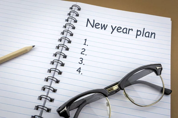 Vintage glasses old on a notebook of work with new year plan words as — Stock Photo, Image