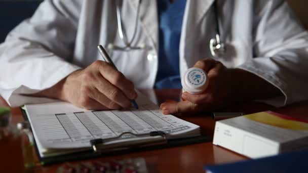 Doktor, tıbbi muayene ya da reçete üzerine hasta notları yazıyor. — Stok video