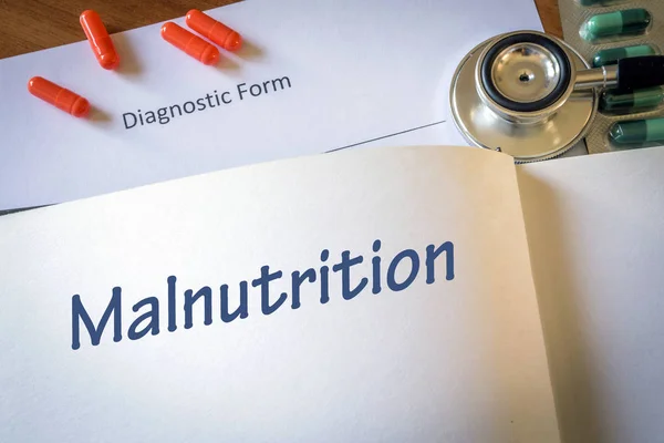 Diagnóstico desnutrición escrita en forma diagnóstica y pastillas — Foto de Stock