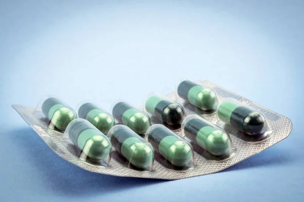 Close up de pílulas médicas isoladas em fundo azul — Fotografia de Stock