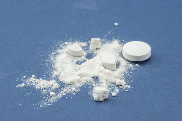 Still life of pills and its powder on blue background — Stock Photo, Image