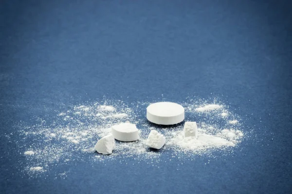 Still life of pills and its powder on blue background — Stock Photo, Image