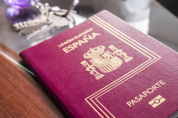 Tuşları ve bir masa saati yanında İspanyol pasaportu