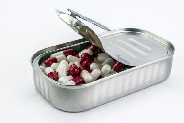 Metal de lata contiene píldoras blancas y rojo — Foto de Stock