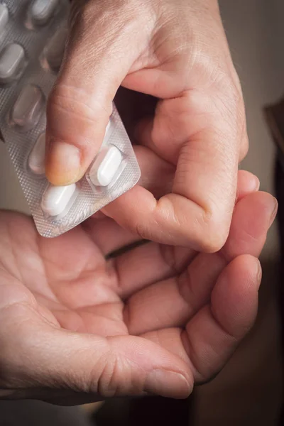 Γυναίκες Πάρτε λευκό χάπι με το αριστερό χέρι από ένα δισκίο χάπια — Φωτογραφία Αρχείου