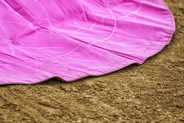 Fechado de uma capa de luta de pano da tela de cor rosa na areia — Fotografia de Stock