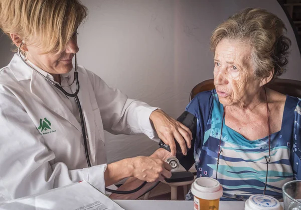 Lékař měří krevní tlak na oldster doma, Andalusie, Španělsko — Stock fotografie