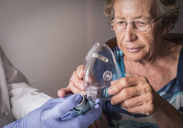 Lékař vysvětluje staré ženě, jak funguje ventimask inhalační školení, Andalusie, Španělsko — Stock fotografie