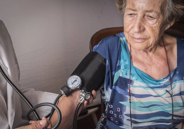 Médico mide la tensión arterial al anciano en casa, Andalucía, España —  Fotos de Stock