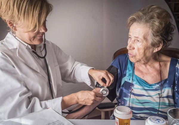 Medico misura la tensione arteriosa a oldster a casa, Andalusia, Spagna — Foto Stock