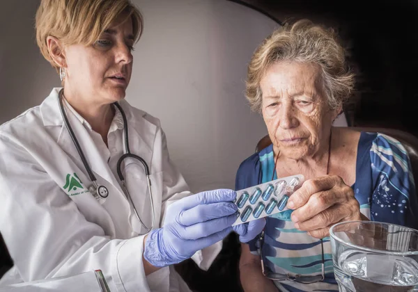 Lékař vysvětluje postarší denní dávku léků, Andalusie, Španělsko — Stock fotografie