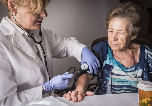 Läkaren mäter arteriell spänningen till oldster hemma, Andalusien, Spanien — Stockfoto