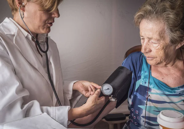 Medico misura la tensione arteriosa a oldster a casa, Andalusia, Spagna — Foto Stock