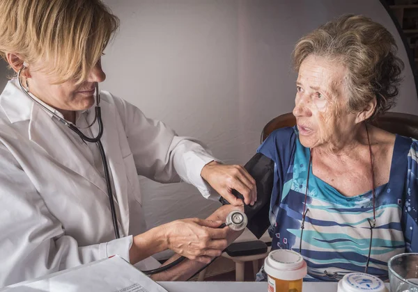 Médico mede a tensão arterial ao oldster em casa, Andaluzia, Espanha — Fotografia de Stock