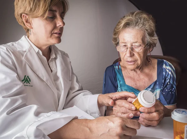 Médico explica a los ancianos dosis diaria de medicamentos, Andalucía, España —  Fotos de Stock