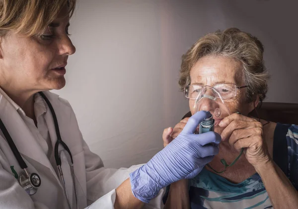 El médico explica a la anciana cómo funciona el entrenamiento por inhalación con máscara ventilatoria, Andalucía, España —  Fotos de Stock