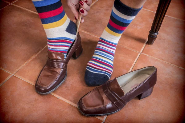 Woman putting on shoes to him vintage with colors socks — Stock Photo, Image