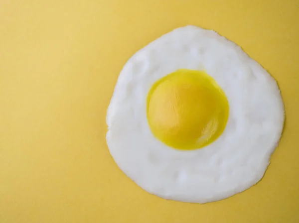 Ovo frito isolado em um fundo amarelo — Fotografia de Stock