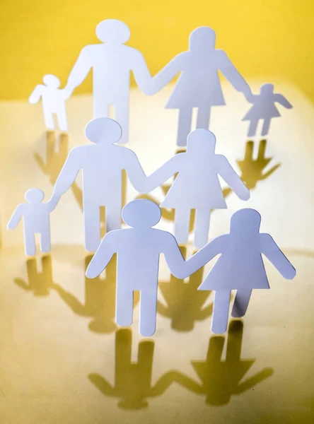 Silhouette familiari con bambini isolati su sfondo giallo, immagine concettuale — Foto Stock