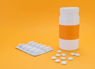 Turuncu zemin üzerine açık bir şişe dökmek pills