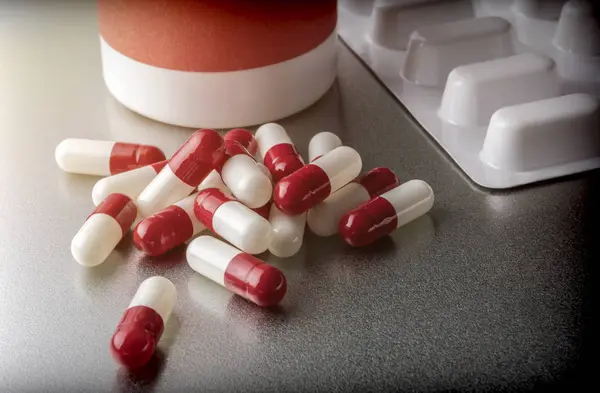 Some white and red capsules along with closed boat, conceptual image — Stock Photo, Image