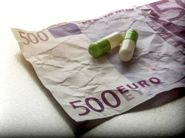 Deux capsules de blanc et de vert sur un billet utilisé 500 euros, image conceptuelle — Photo