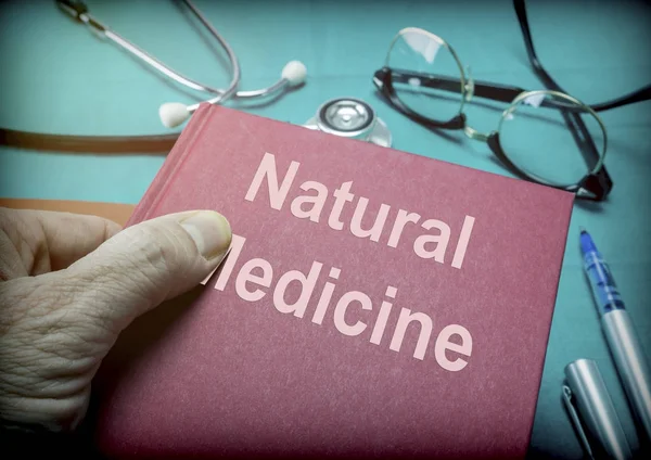 Doctor supports a book of natural medicine in a medical laboratory