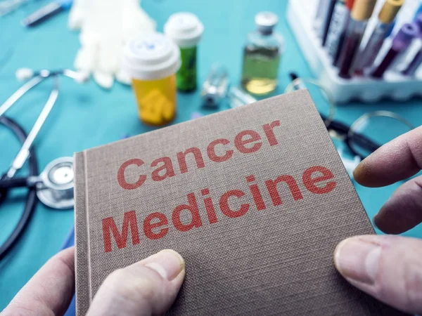 Доктор держит в руках книгу о раке, концептуальном образе — стоковое фото