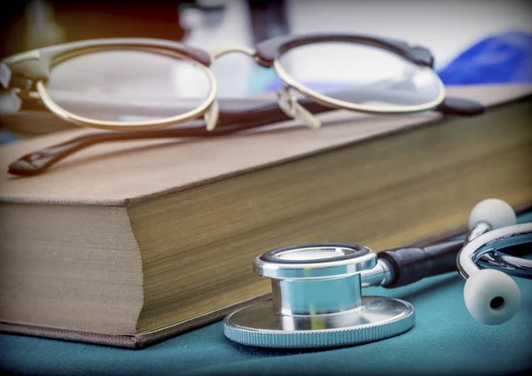 Orvosi könyvek mellett a sztetoszkóppal és a szemüveg, a fogalmi kép — Stock Fotó
