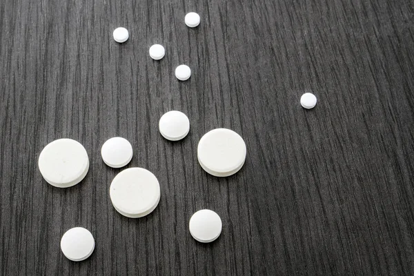 Algumas pílulas brancas redondas de tamanho diferente — Fotografia de Stock