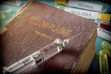  Vintage Syringe On A Book Of yellow plague, Medical Concept  clipart