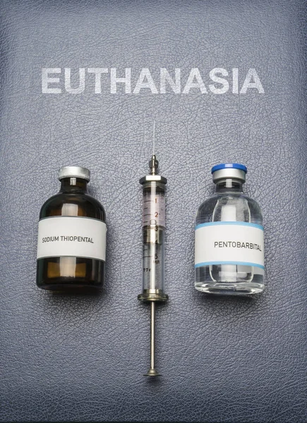 Jeringa vintage y fármacos utilizados en la inyección letal en un libro de eutanasia, composición digital, imagen conceptual — Foto de Stock