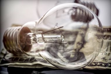 Bir ampul dolarlık banknot, enerji tasarrufu kavramı üzerinde