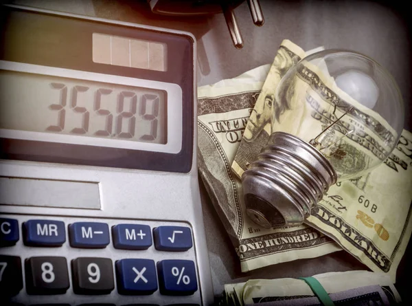 Taschenrechner Und Geld Neben Einer Glühbirne Das Konzept Des Energiesparens — Stockfoto