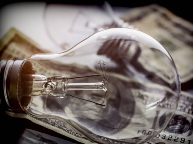 Bir ampul dolarlık banknot, enerji tasarrufu kavramı üzerinde