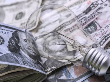 Bir ampul dolarlık banknot, enerji tasarrufu kavramı üzerinde