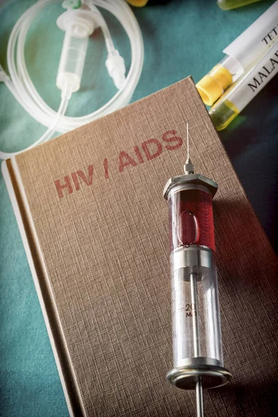 Vintage Syringe On A Book Of HIV and AIDS, Medical Concept