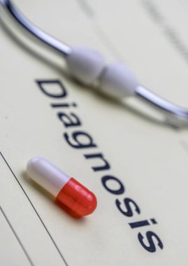 Kırmızı ve beyaz kapsül bir stetoskop, kavramsal görüntü yanında