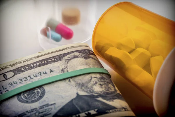 Sommige medicijnen naast een blok van tickets van de dollar, conceptuele — Stockfoto