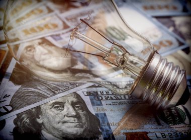Bir ampul dolarlık banknot, enerji tasarrufu kavramı üzerinde