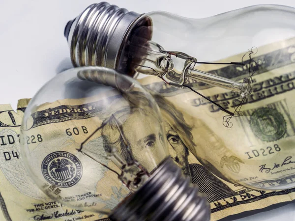 A lightbulb on dollar bill, energy saving concept — Stock Photo, Image