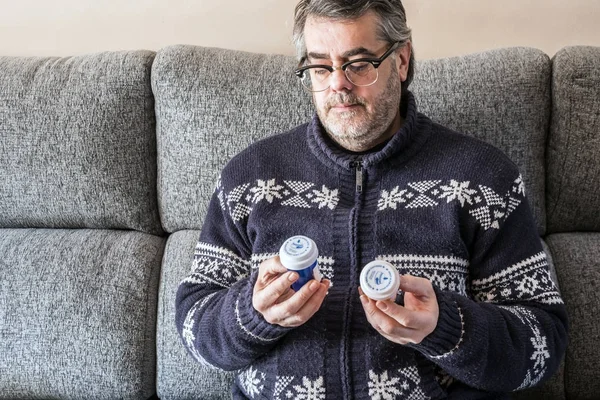 Paciente parece dudoso dos barcos de pastillas en su casa, concepto —  Fotos de Stock