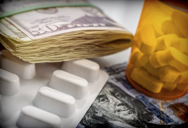 Sommige medicijnen naast een blok van tickets van de dollar, conceptuele — Stockfoto