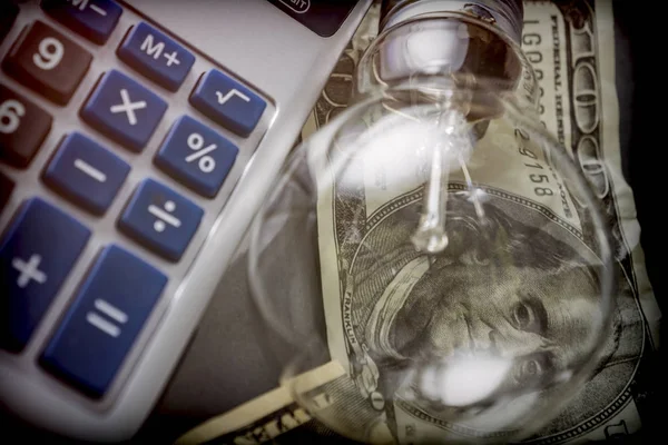 電卓と電球、省エネの概念の横にお金 — ストック写真