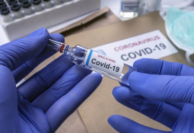  Bilim adamı Coronavirus aşısını hastanede, kavramsal görüntüde tutuyor.