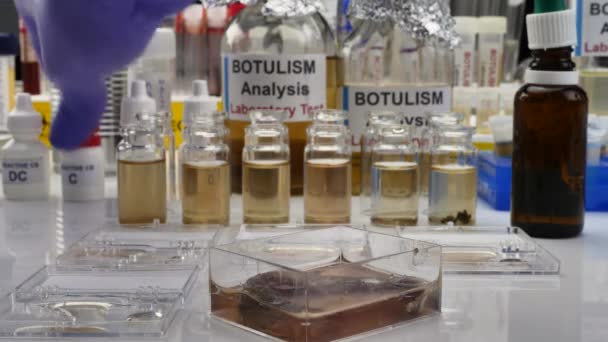경험있는 실험실 과학자는 통조림된 식품에서 샘플을 분석하여 환자의 보툴리누스 감염을 — 비디오